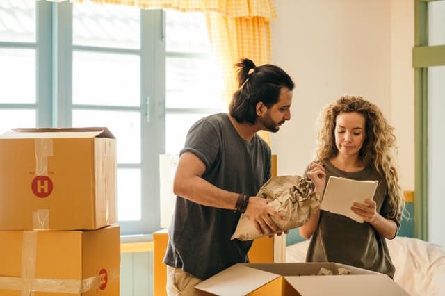 Husband and wife wrapping moving items